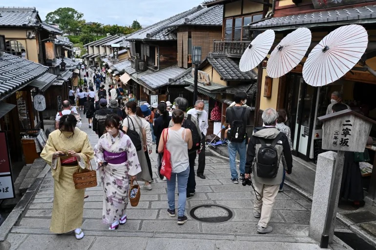 Du khách đi bộ dọc theo một trong những con đường có nhiều cửa hàng và nhà hàng dành cho khách du lịch dẫn đến chùa Kiyomizu-dera ở Kyoto vào ngày 13 tháng 10 năm 2022.