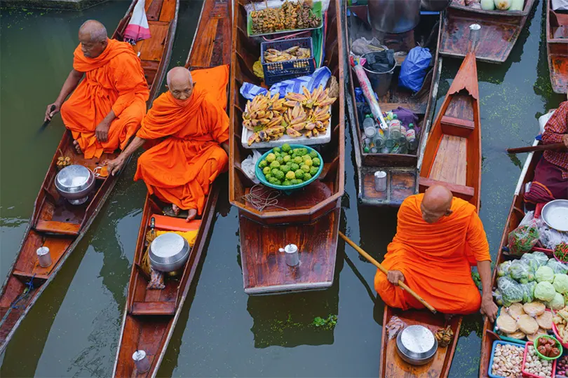 Các nhà sư đi khất thực bằng thuyền trên chợ nổi. Ảnh: TAT