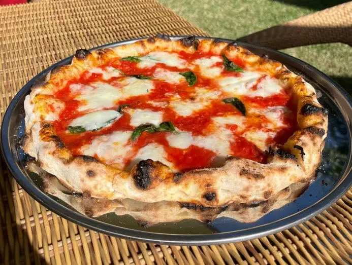Pizza margherita cổ điển của PST có lớp vỏ phồng và phần giữa mỏng.