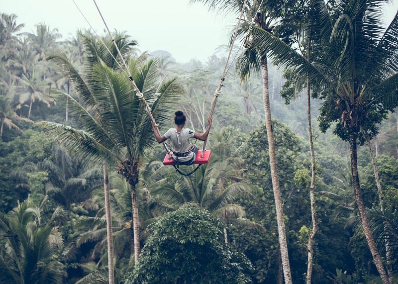 Bay lên bầu trời trên một trong những xích đu trong rừng ở Bali