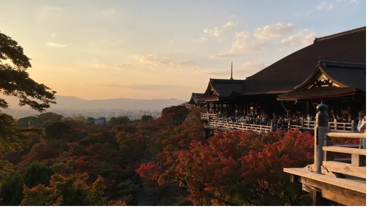 Du khách tụ tập trên sân thượng gần Kiyomizu-dera để ngắm hoàng hôn và lá mùa thu ở Kyoto, Nhật Bản.