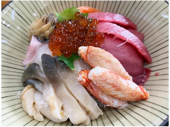▼ Có quá nhiều hải sản trong bát đến nỗi Seiji không thể nhìn thấy cơm bên dưới.
