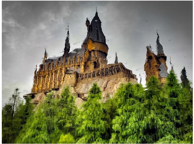 Những giọt mưa và hình ảnh phản chiếu của Trường Phù thủy và Pháp sư Hogwarts trên một hồ nước ở Universal Studios Japan.