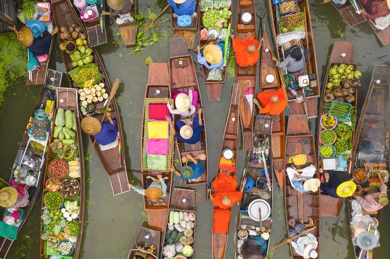 Một góc nhìn từ trên không của những người buôn bán và các nhà sư trong một khu chợ nổi trên một con kênh ở Thái Lan