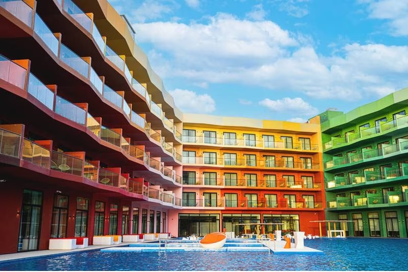 Cote d’Azur Monaco Hotel hiện ra lờ mờ trên một hồ bơi lớn, hoàn chỉnh với những chiếc ghế nằm ngập nước.
