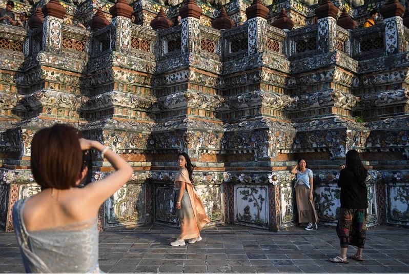 Khách du lịch từ Trung Quốc đại lục mặc trang phục truyền thống của Thái Lan đến thăm chùa Wat Arun trước Tết Nguyên đán khi Trung Quốc mở cửa lại biên giới ở Bangkok, Thái Lan vào ngày 18 tháng 1 năm 2023.