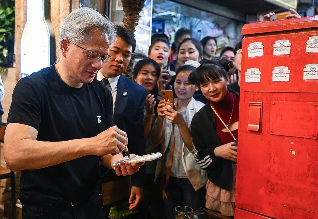 CEO tập đoàn công nghệ Nvidia Jensen Huang (áo đen) giao lưu với người dân khi đi ăn khuya tại phố tây Tạ Hiện, Hà Nội hồi tháng 12/2024. Ảnh: Giang Huy