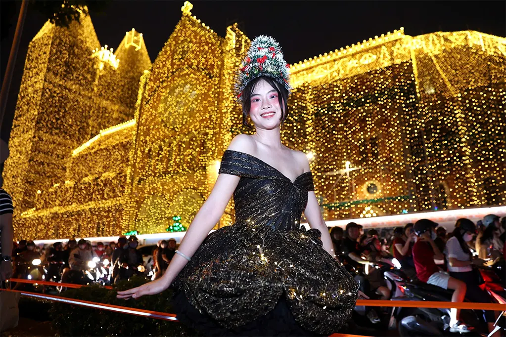 Du khách chụp hình trước Nhà thờ Đức Bà Sài Gòn đêm Giáng sinh. Ảnh: Quỳnh Trần