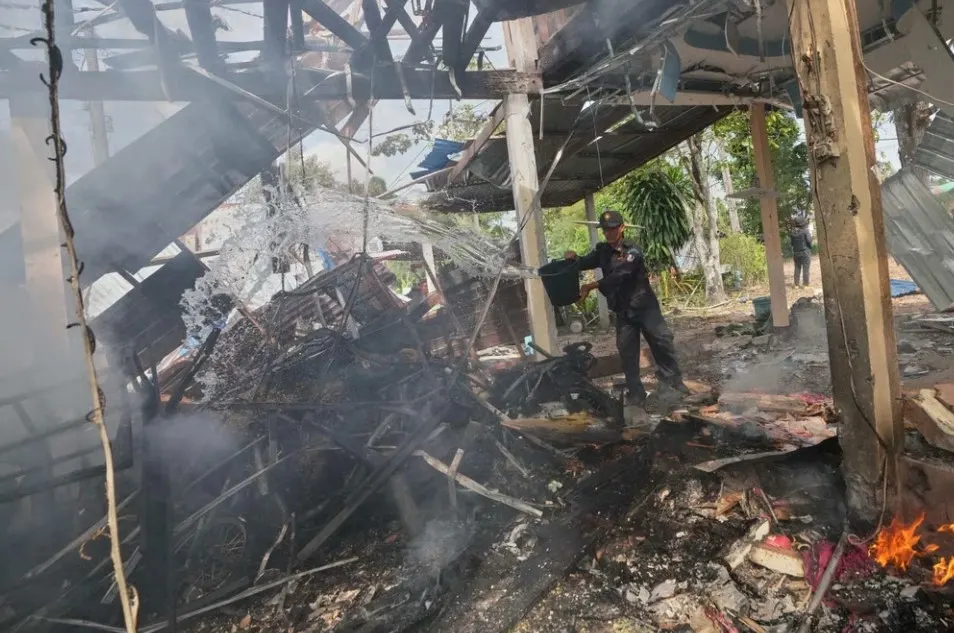 Tình nguyện viên đang dập tắt đám cháy tại ngôi nhà quân đội Thái Lan cho biết đã bị trúng đạn pháo của Campuchia ở tỉnh Sisaket, ngày 14/12. Ảnh: AP