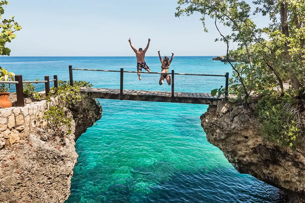 Hai du khách nhảy xuống biển ở Negril, Jamaica.