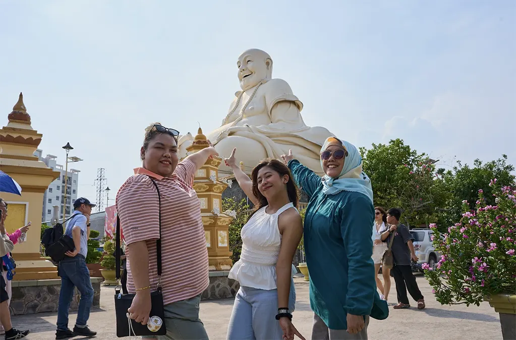 Du khách Indonesia thích thú check-in bên tượng Phật Di Lặc trong hành trình tham quan Mỹ Tho, Tiền Giang ngày 7.5