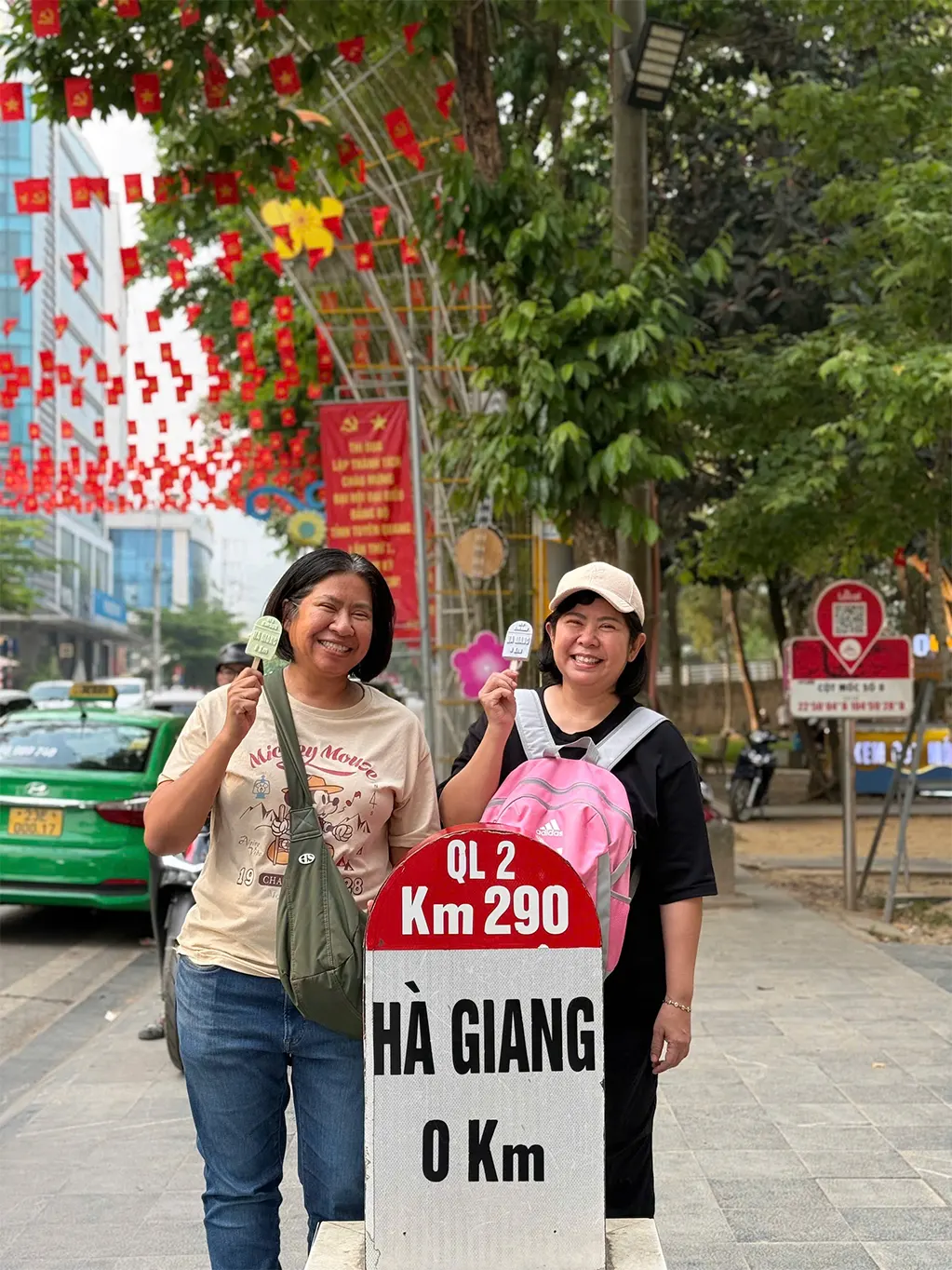 Du khách Thái Lan ăn kem, chụp ảnh với cột mốc Km số 0 ở Hà Giang hồi giữa tháng 5. Ảnh: Cao Ngọc Sơn